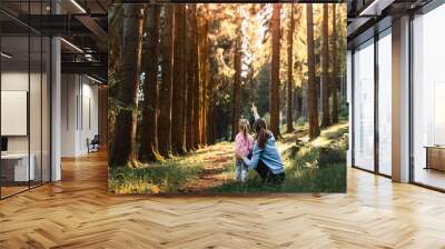 Mother child bonding in autumn forest, enjoying wildlife learning about nature Wall mural