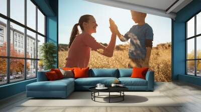 Mother giving son high five. Parent child relationship concept Wall mural