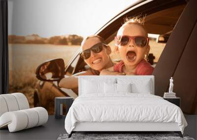 parent and child on vacation enjoying a road trip in a car, smiling and bonding Wall mural