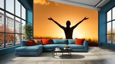 People feeling happy and personal wellbeing. Happy female sitting outdoors with arms up facing the sunset. Wall mural