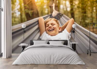 Portrait little cute adorable carefree caucasian boy smiling happy resting in hammock outdoors, people portrait  Wall mural