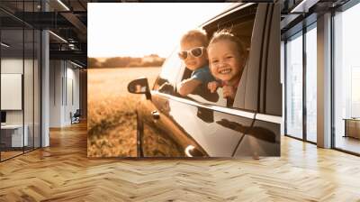 Portrait of happy little boy and girl in car. Family road trip,  summer holiday travel concept.  Wall mural