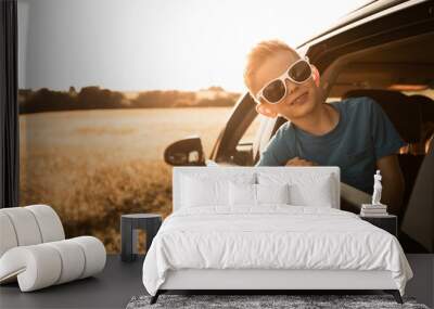 Portrait of happy little boy in car, summer fun family roadtrip  Wall mural