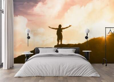 silhouette of a man on top of the mountain with arms outstretched  Wall mural