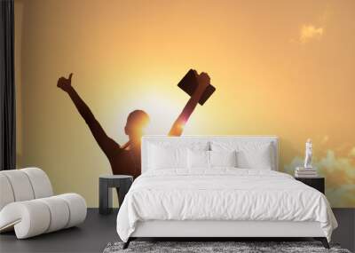 silhouette of inspire female holding up book to the sky with thumbs up. Education, and religious belief concept Wall mural