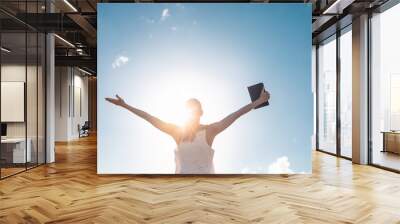 Strong, happy motivated woman holding bible  Wall mural