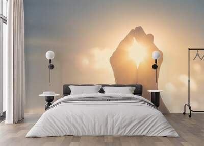 Woman's hands holding the sun at dawn. Freedom and spirituality concept.  Wall mural