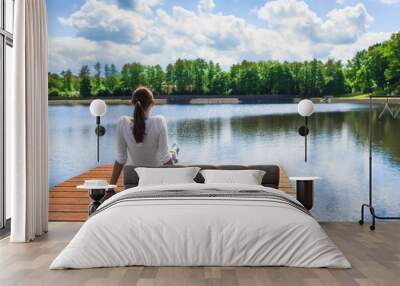 Woman relaxing by a beautiful lake.  Wall mural