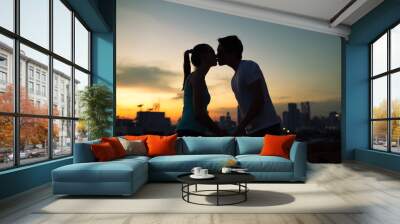 young couple int he city kissing at sunset Wall mural