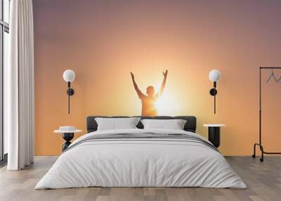 Young man lifting hands up to the sky feeling happy and free.  Wall mural