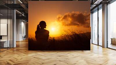 Young woman taking a moment to relax and watch the sunset.  Wall mural