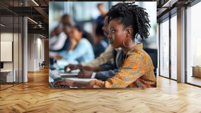 A group of diverse people worked together in an office, each focused on their own computer screen with the main focus being one woman sitting at her desk typing away on her keyboard. Wall mural