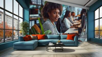 A group of diverse people worked together in an office, each focused on their own computer screen with the main focus being one woman sitting at her desk typing away on her keyboard. Wall mural