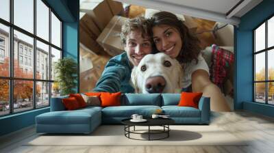 A happy young couple taking a selfie with a white labrador dog in their new apartment surrounded by moving boxes Wall mural