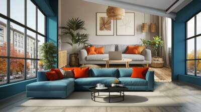 A modern living room with wooden flooring, a grey sofa and a white rug. A wood side table holding an open laptop computer. Two orange pillows on the couch. Wall mural