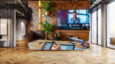 business women in an office setting, smiling and working together on digital tablet with documents spread out nearby. Wall mural