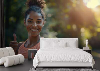 Portrait of a happy young woman doing a thumbs up with copy space, wearing sportswear and smiling while showing a hand gesture in nature. Wall mural