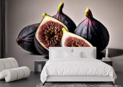 Three black figs, one sliced in half, on a white background. Wall mural