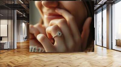 Close-up of a young woman wearing a diamond ring on her left ring finger, a gift from a marriage proposal. Happiness concept suitable for marriage Wall mural