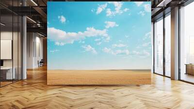 Vast golden fields under a bright blue sky with fluffy white clouds. Wall mural