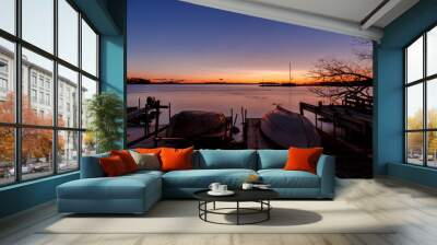 two small boats lying up and down on the jetty at sunset Wall mural