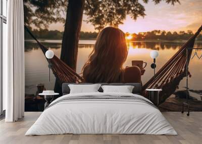 Back View of young woman fictional swing on the hammock in front of water  Wall mural