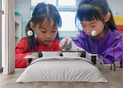 Two Asian kindergarten students are building a machine using different metal components in a very bright classroom.  Wall mural