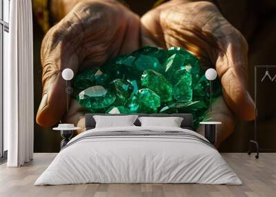 A pair of hands holding a collection of vibrant green gemstones. Wall mural