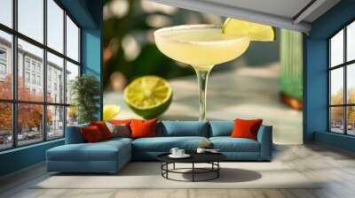 A refreshing margarita cocktail in a coupe glass, garnished with a lime wedge, on a white marble surface with a lime wedge in the background. Wall mural