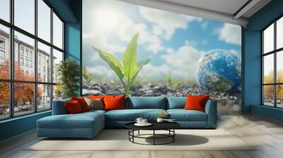 A small green sprout grows from the earth with a miniature globe resting in the ground. Wall mural