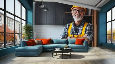 A smiling older man in a hard hat and overalls stands in a modern kitchen setting. Wall mural