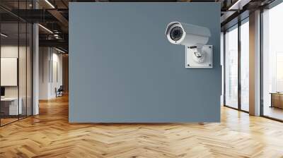 A surveillance camera mounted on a gray wall, used for security monitoring. Wall mural