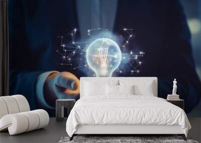 Businessman holding a glowing light bulb representing innovation and creativity Wall mural