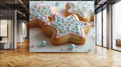 Close up of two star-shaped cookies with blue, pink and white frosting and sprinkles. One of the cookies is a blur in the background. Wall mural