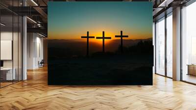 Three silhouetted crosses against a vibrant sunset, symbolizing faith and reflection. Wall mural