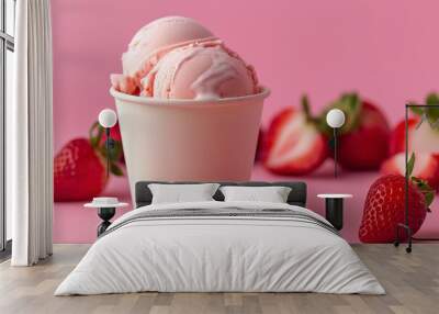 Two scoops of strawberry ice cream in a white paper cup with fresh strawberries on a pink background. Wall mural