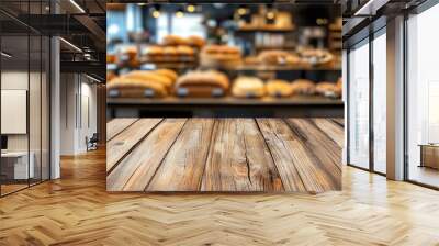 Empty wooden table in front of a bakery with fresh bread and pastries on display. Wall mural