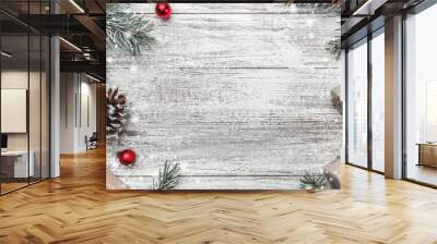 Christmas theme with fir branches, cones, globes, red bows, present boxes on white wooden background viewed from above, in snow, greeting card with space for text Wall mural