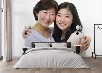 Korean mother and her teenage daughter standing together, smiling and hugging each other, highlighting their close relationship and happiness Wall mural