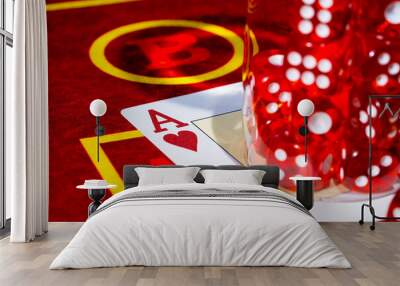 A red casino table with an ace of hearts and a set of red dice in a glass. Close up of cards and dice for playing craps, poker or roulette. Gambling club. Game for money, bets, risk, success. Wall mural