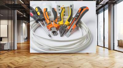 set of electrician tools, a coil of wire and equipment in backgr Wall mural