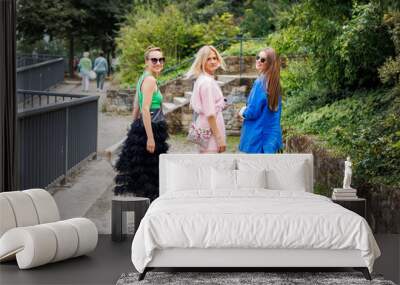 Back view three cheerful young adult women friend walk street old european german town city street park enjoy have fun laughing sunny day together. Female persons friendship celebration party weekend Wall mural