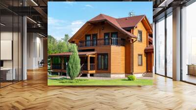 Beautiful luxury big wooden house. Timber cottage villa with with green lawn, garden and blue sky on background Wall mural