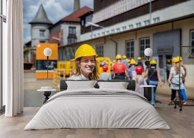 Portrait happy woman tourist wear yellow safety helmet equipment at Rammelsberg Unesco Mine trip entrance group tour. Tourism at industrial miner area Goslar Harz, Germany. Extreme mountain adventure Wall mural