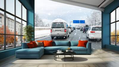 Winter highway with many different cars stucked in traffic jam due ti bad weather conditions. Vehicles on road during heavy snowstorm and blizzard on cold winter day in Austria near Germany border Wall mural