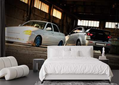 Two cars in an abandoned hangar. Wall mural