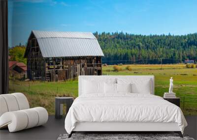 A rundown vintage rustic barn with metal roof in the rural mountain town of Athol, in the Coeur d'Alene, Idaho area of Northwest, USA Wall mural