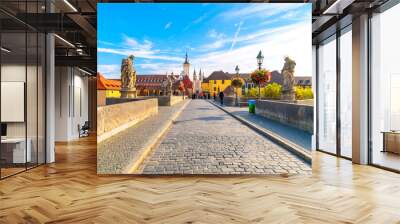 The Old Main bridge or Mainbrücke, with statues of holy figures and the Wurzburg Cathedral and towers Grafeneckart and St. Kiliansdom in view, in the Bavarian city of Würzburg, Germany. Wall mural