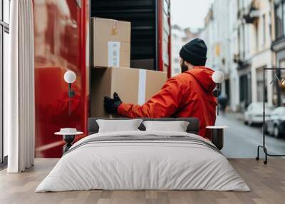 A man swiftly loads a box from a moving truck into a warehouse, showing efficiency in logistics and distribution. Wall mural