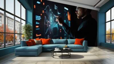 Caucasian male professional using an advanced digital interface with futuristic graphics in a dark workspace. Wall mural